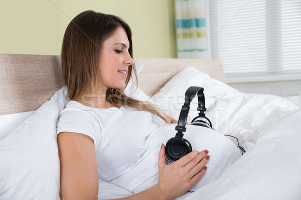 Pregnant Woman Putting Headphone On Her Belly Stock photo © AndreyPopov