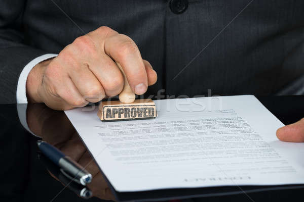 Close-up Of Businessman Hand Stamping On Approved Contract Form Stock photo © AndreyPopov
