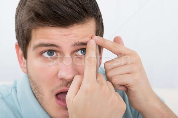 Stock photo: Man Looking At Pimple On Forehead