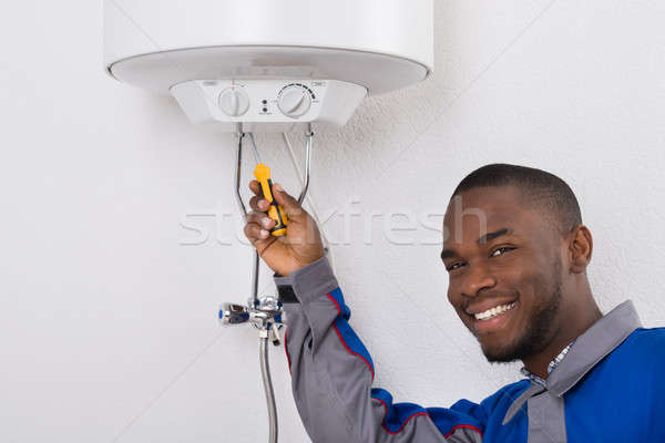 Worker Fixing Electric Boiler With Screwdriver Stock photo © AndreyPopov