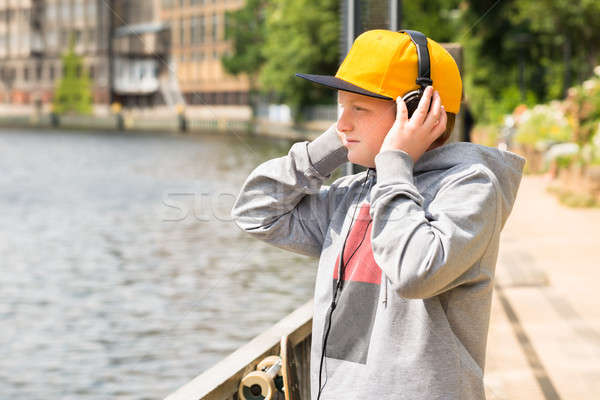 Boy Looking At Lake While Listening To Music Stock photo © AndreyPopov