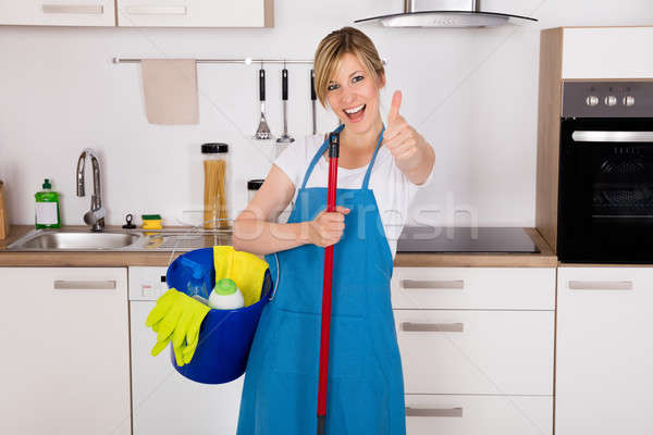 Housemaid Showing Thumbs Up In Kitchen Stock photo © AndreyPopov