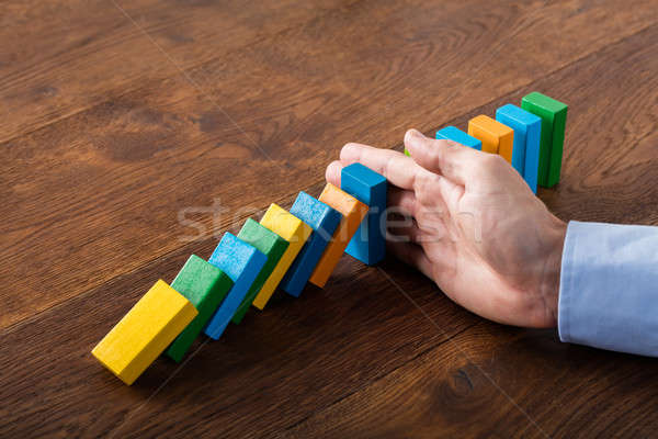 Person Hand Stopping Dominoes Stock photo © AndreyPopov