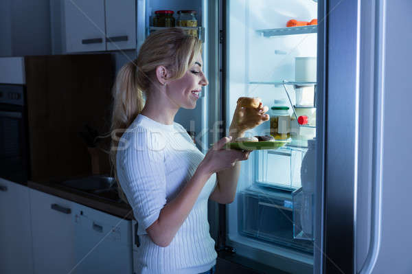 Kadın yeme tatlı gıda buzdolabı genç mutlu Stok fotoğraf © AndreyPopov