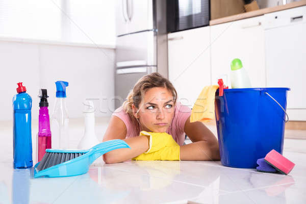 Woman Lying On Kitchen Floor And Looking At Cleaning Products Stock photo © AndreyPopov