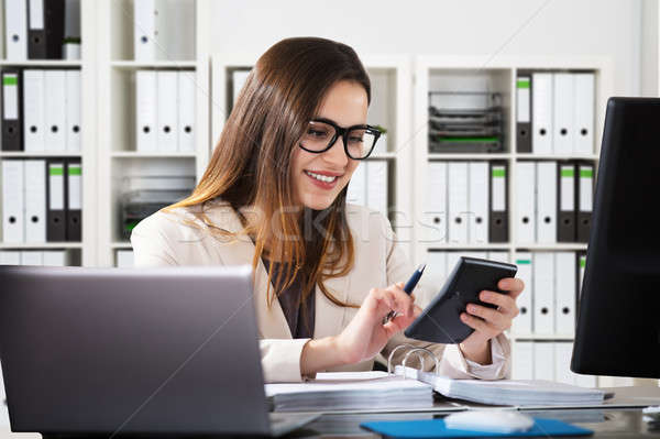 Happy Businesswoman Using Calculator Stock photo © AndreyPopov