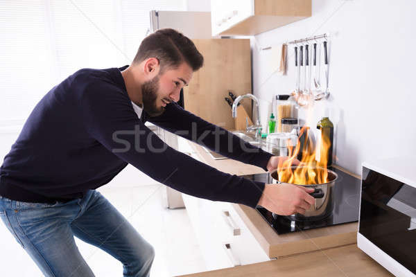 Man Holding Utensil On Fire Stock photo © AndreyPopov