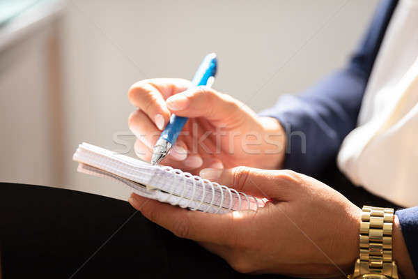 Femme d'affaires écrit note spirale notepad Photo stock © AndreyPopov