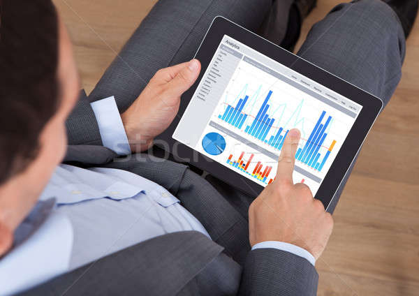 Businessman Comparing Graphs On Digital Tablet Stock photo © AndreyPopov