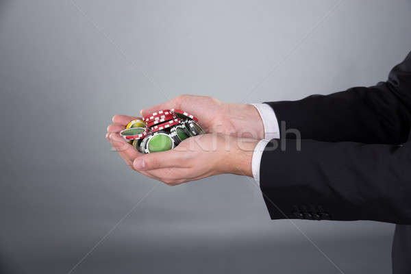 Businessman's Hands Holding Poker Chips In Cupped Hands Stock photo © AndreyPopov