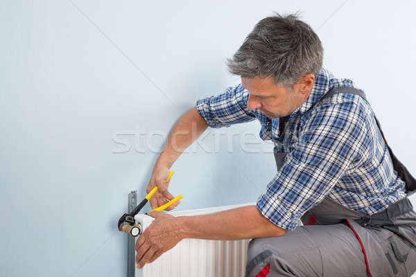 Plumber Fixing Radiator With Wrench Stock photo © AndreyPopov