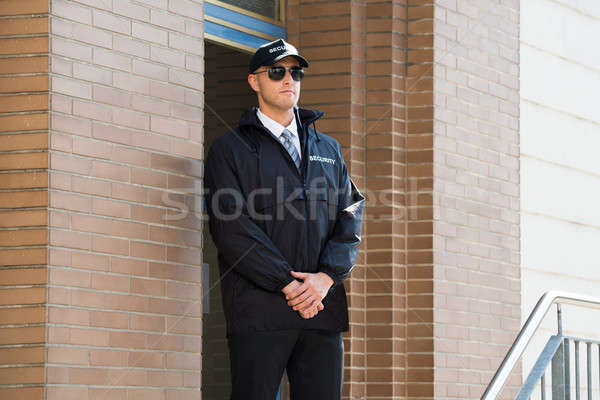 Masculina guardia de seguridad pie entrada jóvenes pared Foto stock © AndreyPopov