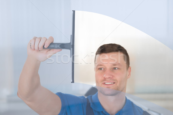 Worker Cleaning Glass Window With Squeegee Stock photo © AndreyPopov