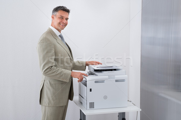 Geschäftsmann Papier Maschine Büro Seitenansicht Mann Stock foto © AndreyPopov