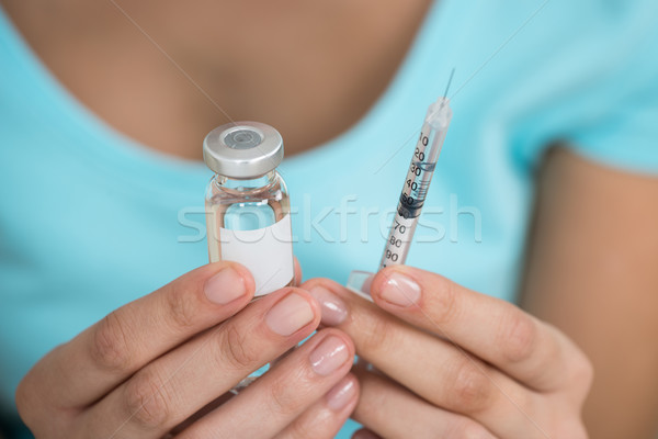 Woman Holding Medicine Bottle And Syringe Stock photo © AndreyPopov