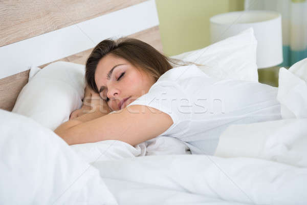 Young Woman Sleeping In Bedroom Stock photo © AndreyPopov