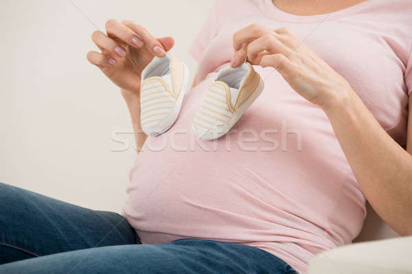 Expecting Woman Holding Small Shoes For Unborn Baby Stock photo © AndreyPopov