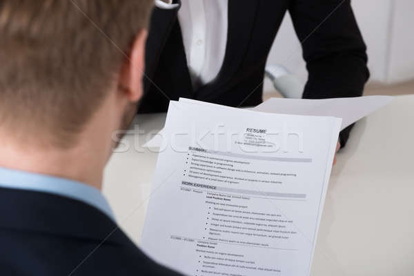 Businessman Analyzing Resume At Desk Stock photo © AndreyPopov