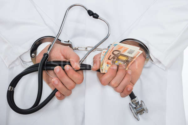 врач евро банка отмечает наручники Сток-фото © AndreyPopov
