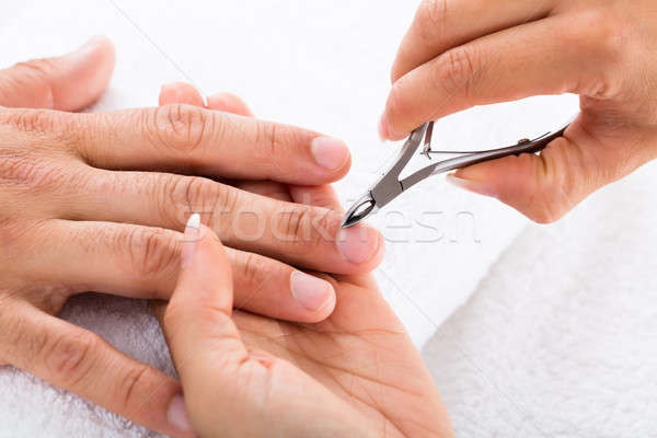 Manicurist Cutting Off The Cuticle From The Person's Fingers Stock photo © AndreyPopov