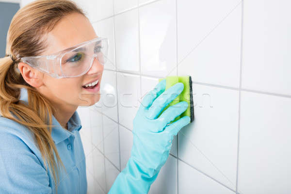 Mujer limpieza blanco azulejo pared Foto stock © AndreyPopov