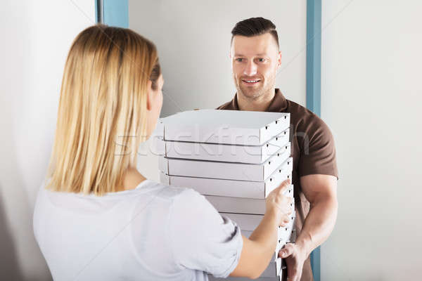 Man Delivering Stack Of Pizza Stock photo © AndreyPopov