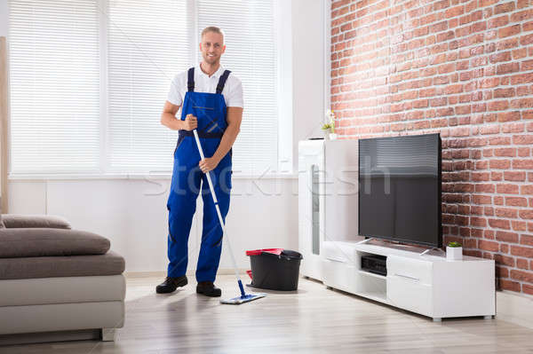 Male Janitor Sweeping Floor At Home Stock photo © AndreyPopov