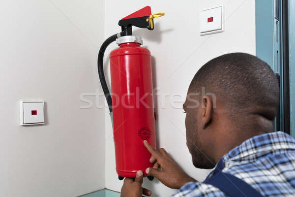Male Professional Checking A Fire Extinguisher Stock photo © AndreyPopov