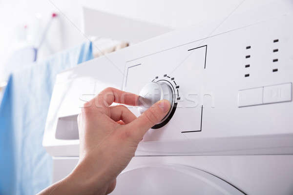 Person Turning Button Of Washing Machine Stock photo © AndreyPopov