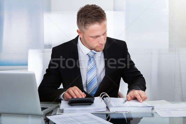 Hardworking businessman analyzing a report Stock photo © AndreyPopov