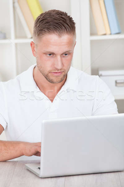 Young man working at home on a laptop Stock photo © AndreyPopov