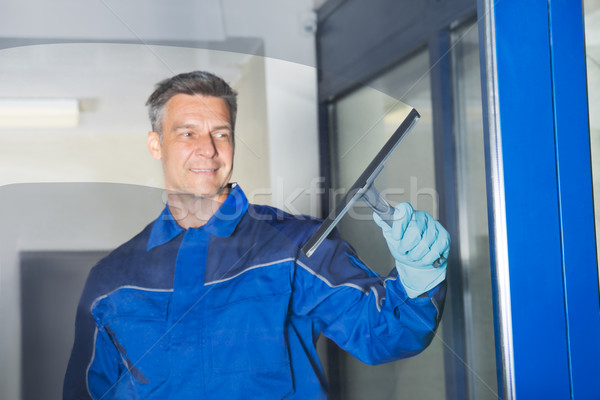 Male Worker Cleaning Glass With Squeegee Stock photo © AndreyPopov