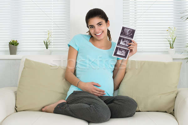 Happy Pregnant Woman Holding Ultrasound Scan On Sofa Stock photo © AndreyPopov