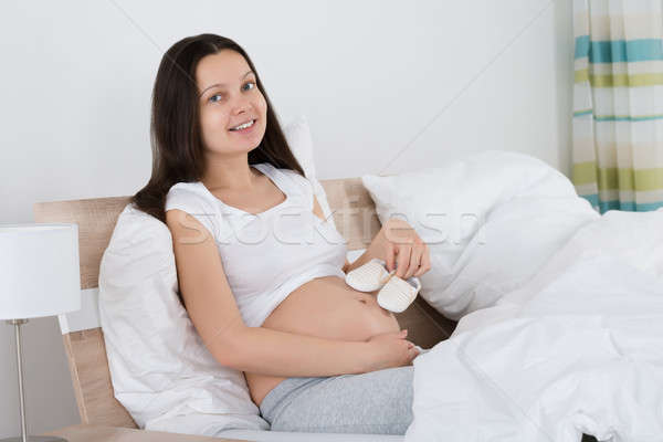 Expecting Woman Holding Small Shoes Stock photo © AndreyPopov