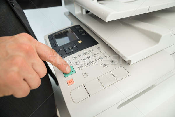 Close-up Of Businessman Pressing Printer's Button In Office Stock photo © AndreyPopov
