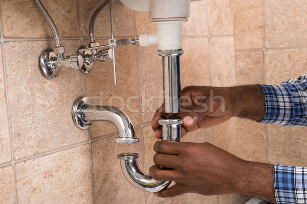 Vízvezeték-szerelők kéz megjavít mosdókagyló fürdőszoba közelkép Stock fotó © AndreyPopov