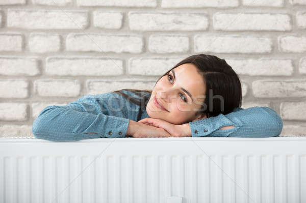 Vrouw achter verwarming radiator portret glimlachende vrouw Stockfoto © AndreyPopov
