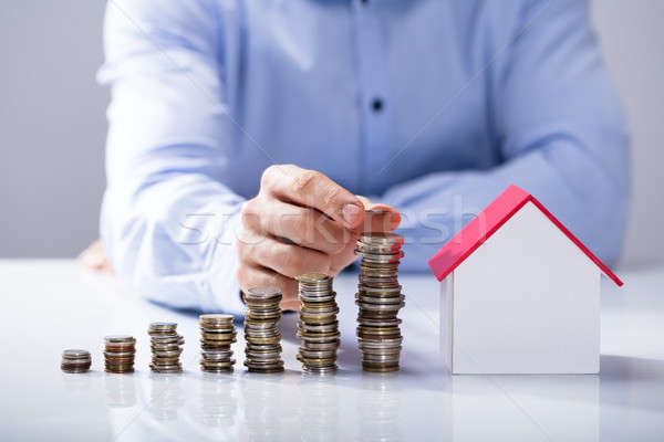 Increased Stack Of Coins In Front Of House Model Stock photo © AndreyPopov
