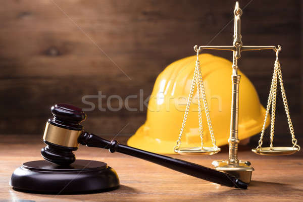 Gavel In Front Of Yellow Safety Helmet And Golden Scale Stock photo © AndreyPopov