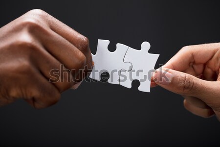 Hands Combining White Puzzle Pieces Stock photo © AndreyPopov