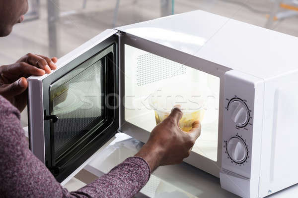 Mano calefacción alimentos microonda horno primer plano Foto stock © AndreyPopov