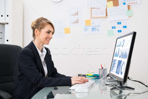 üzletasszony grafikon számítógép fiatal boldog iroda Stock fotó © AndreyPopov
