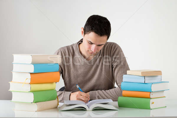 [[stock_photo]]: Jeune · homme · étudier · table · écrit · livre · blanche