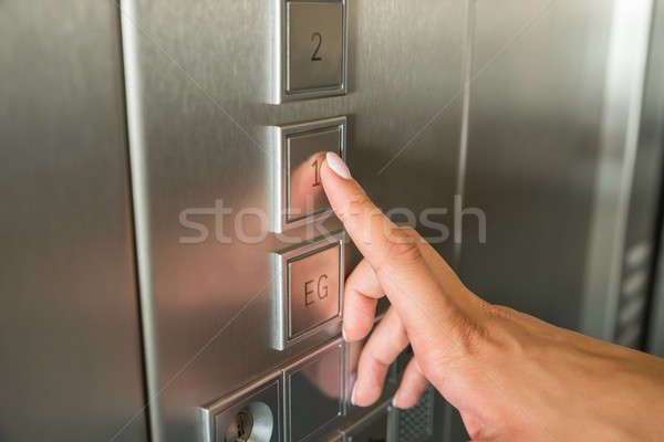 Stock photo: Female's Hand Pressing First Floor Button In Elevator