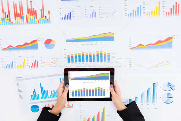 Businesswoman Analyzing Financial Graphs Using Digital Tablet Stock photo © AndreyPopov