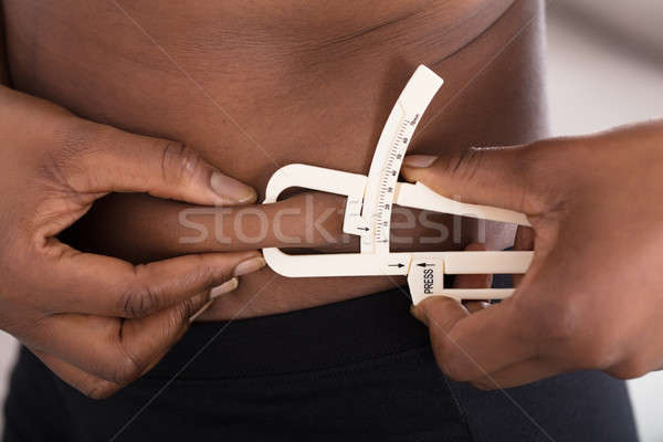 Human Hand Measuring Stomach Fat With Caliper Stock photo © AndreyPopov