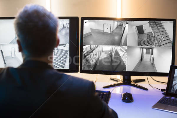 Businessman Looking At CCTV Camera Footage Stock photo © AndreyPopov