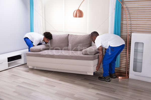 Two Male Movers Placing The Sofa Stock photo © AndreyPopov