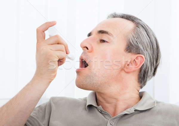 Man with asthma inhaler Stock photo © AndreyPopov