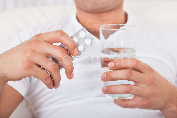 Man With Pack Of Pills And Water Glass Stock photo © AndreyPopov